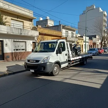 Grúa remolcando una moto azul